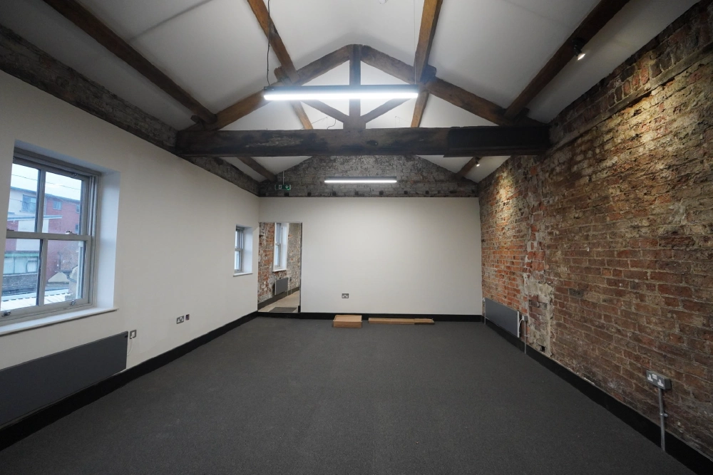 Finished commercial interior with exposed brick and timber beams